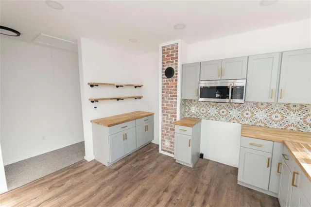 a kitchen with stainless steel appliances white cabinets and a wooden floor