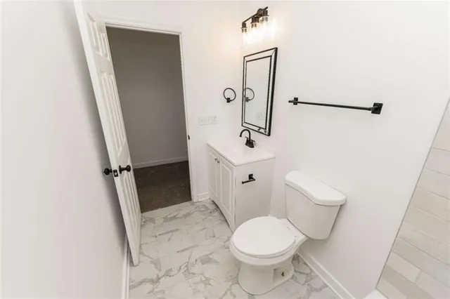 a white toilet sitting next to a sink and a mirror