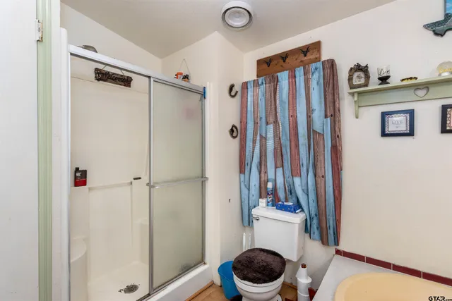 a bathroom with a shower a toilet and tub