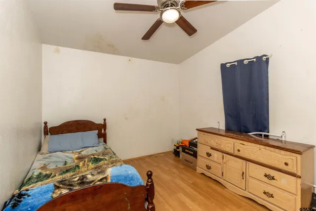 a bedroom with a bed and wooden floor