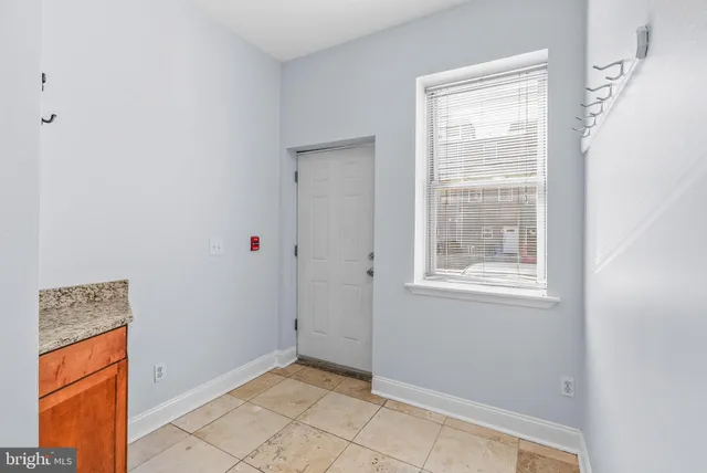 a view of an empty room with closet and a window