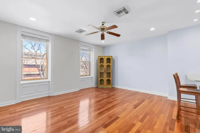a view of a livingroom with a window and wooden floor