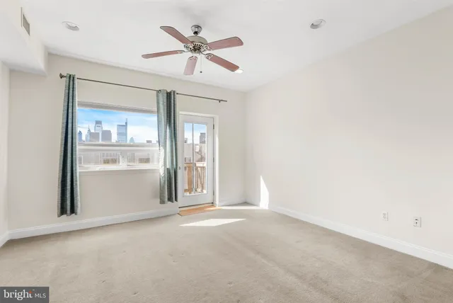 an empty room with chandelier fan