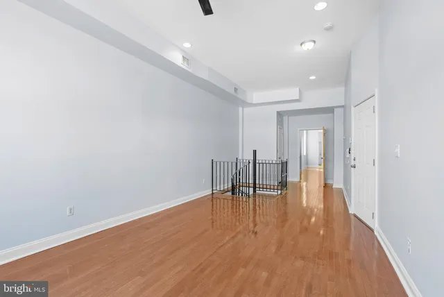 a view of empty room with wooden floor