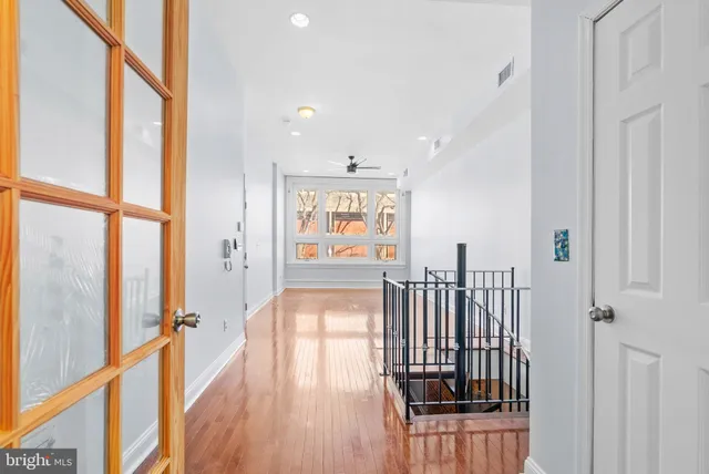 a view of a hallway with wooden floor and windows