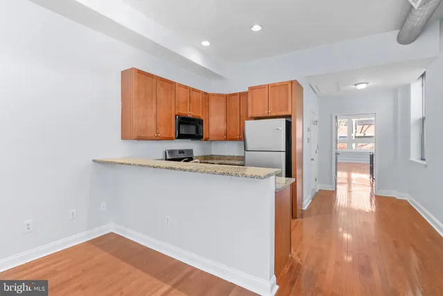 a kitchen with stainless steel appliances granite countertop a refrigerator sink and stove