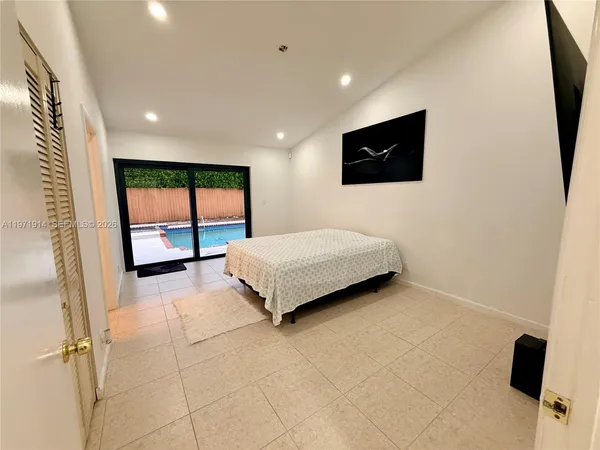 a bedroom with a bed a tv on wall and a window