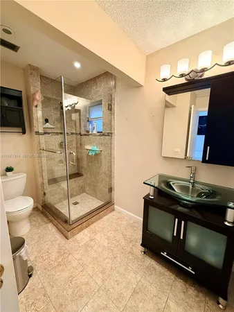 a bathroom with a sink toilet and shower