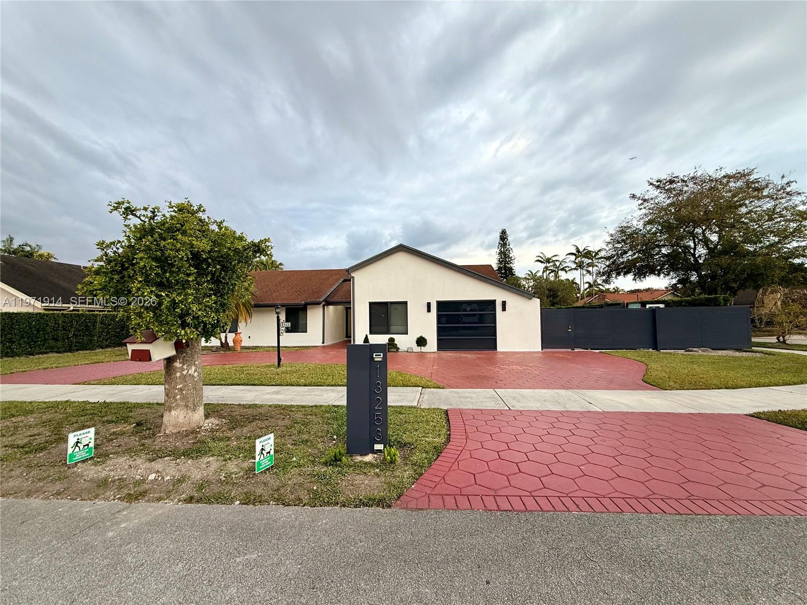 13253 Southwest 96th Terrace Miami, FL 33186 - Photo 2 of 18 a front view of a house with garden