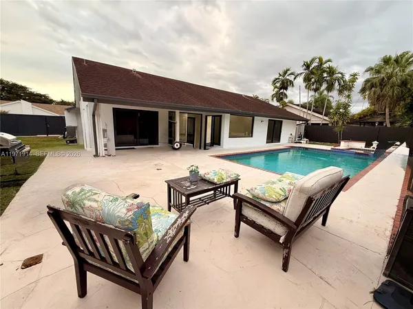 a view of a house with backyard and sitting area