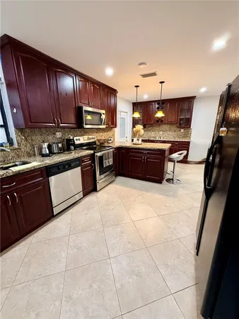 a large kitchen with stainless steel appliances and a stove top oven