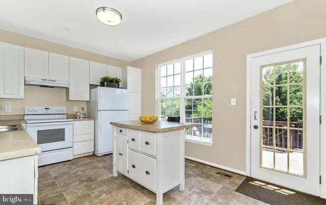 a living room with furniture a fireplace and a large window