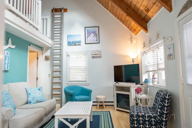 a living room with furniture a flat screen tv and a window
