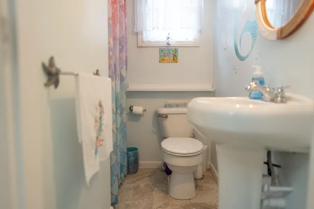 a bathroom with a sink toilet and a mirror
