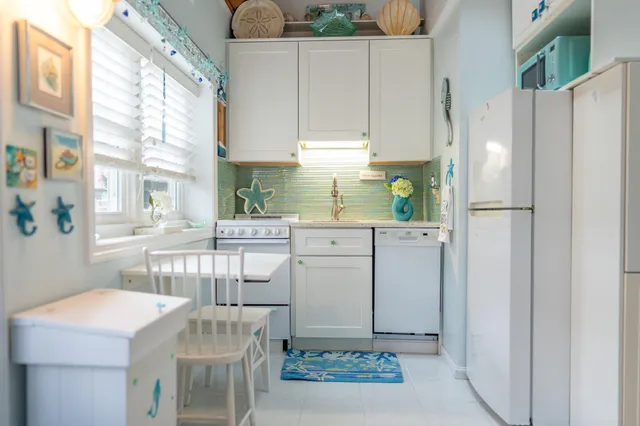 a kitchen with appliances cabinets and a table