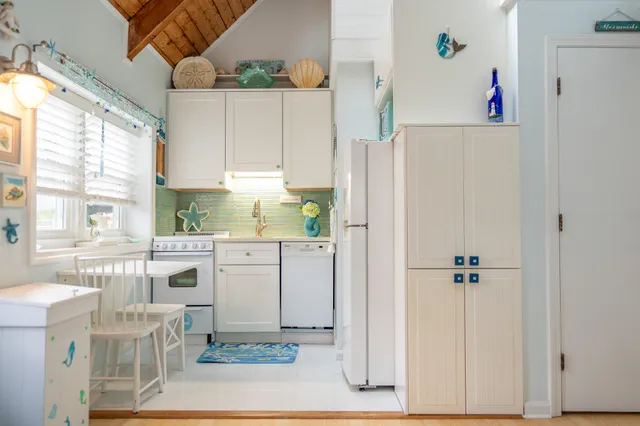 a kitchen with a refrigerator a sink and white cabinets