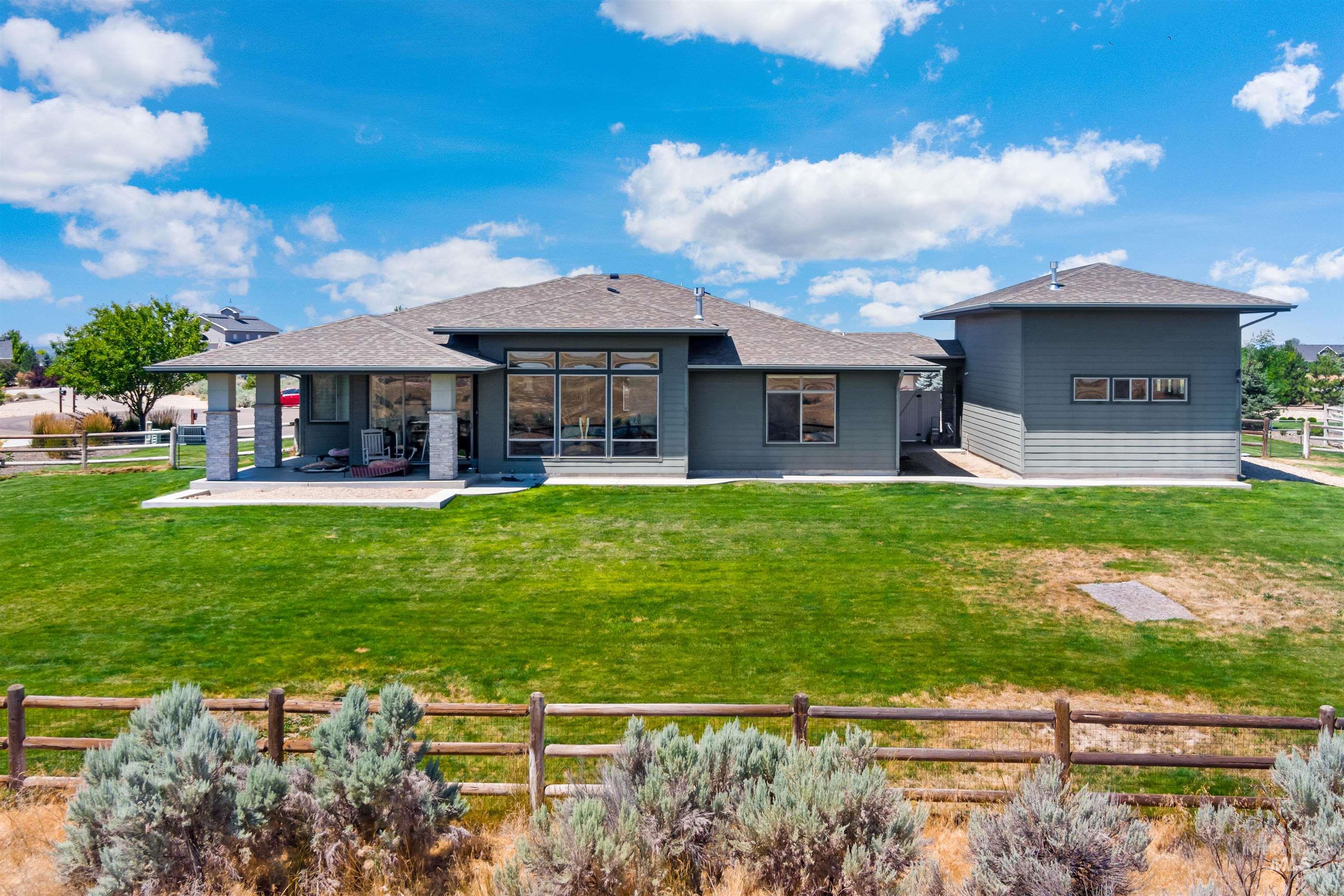 24398 Tombstone Ridge Court Middleton, ID 83644 - Photo 29 of 47 Expansive rear elevation featuring a covered patio with stone-clad columns, large picture windows, and a detached structure