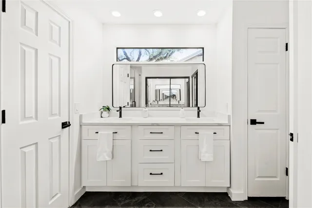 a bathroom with a glass shower door a sink and a mirror