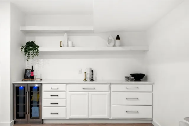an empty room with wooden floor ceiling fan and windows
