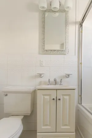 a bathroom with a toilet a sink a mirror and vanity