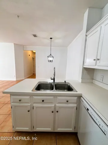 a kitchen with white cabinets and sink