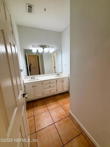 a bathroom with mirror and tiles