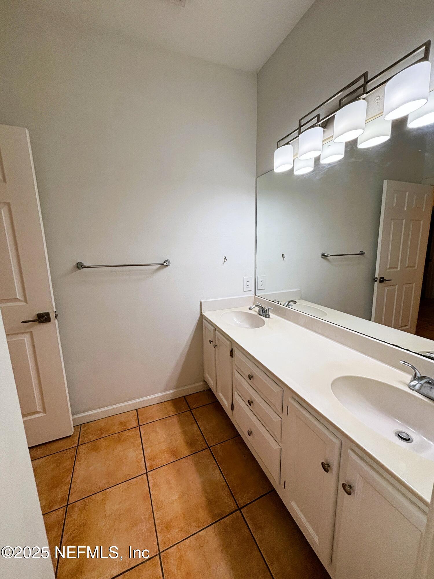 201 Colima Court, Unit 1211 Ponte Vedra Beach, FL 32082 - Photo 25 of 35 a bathroom with a sink a vanity and a mirror