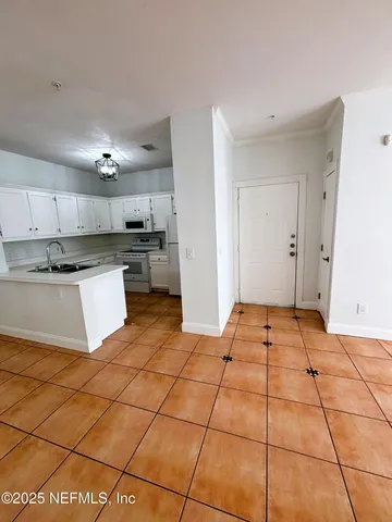 a kitchen with granite countertop a stove a sink and a refrigerator