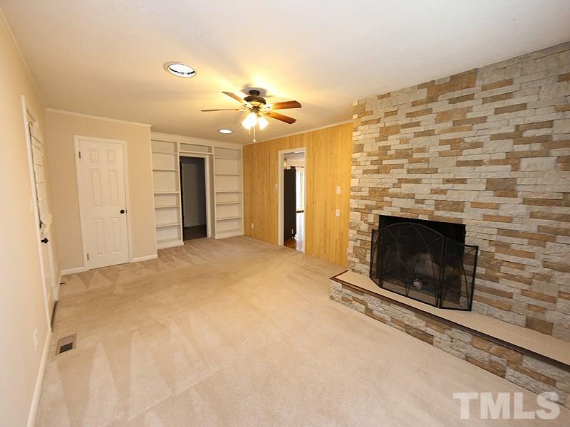 11609 Strickland Road Raleigh, NC 27613 - Photo 5 of 25 Family Room, 21.6 x 13.5, with Big Stone Fireplace, Built-in Bookshelves, Skylight, Ceiling Fan, NEW Paint '14, and Freshly Cleaned Carpet!