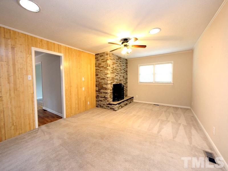 11609 Strickland Road Raleigh, NC 27613 - Photo 6 of 25 Family Room, 21.6 x 13.5, with Big Stone Fireplace, Built-in Bookshelves, Skylight, Ceiling Fan, NEW Energy Efficient Windows '16, NEW Paint '14, Blinds, and Freshly Cleaned Carpet!