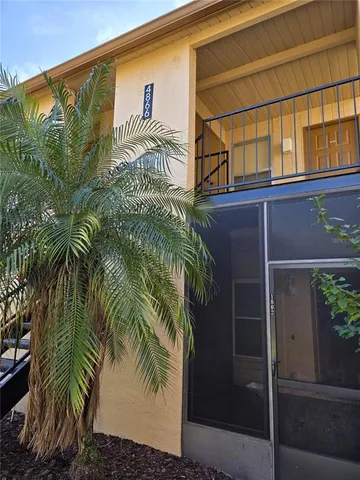 a front view of a house with a tree