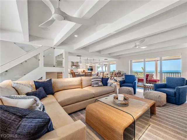 a living room with furniture kitchen view and a wooden floor