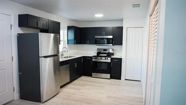 a kitchen with stainless steel appliances granite countertop a refrigerator and a refrigerator