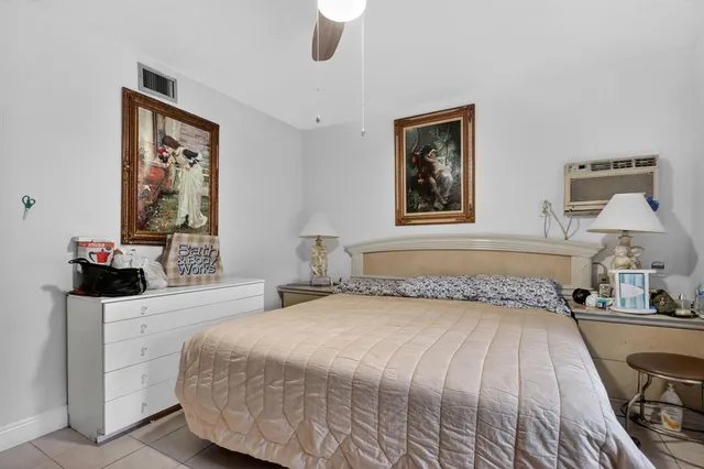 a bedroom with a bed and a lamp on dresser