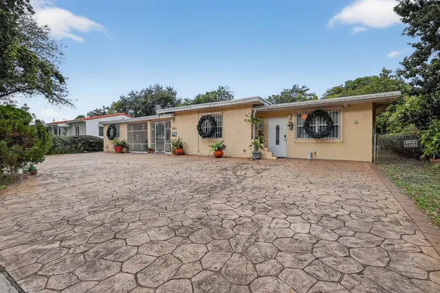 a view of a house with backyard and sitting area