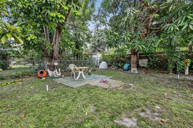 a view of backyard with table and chairs and wooden fence