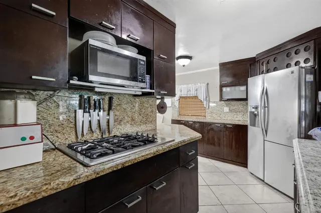 a kitchen with stainless steel appliances granite countertop a stove and a microwave