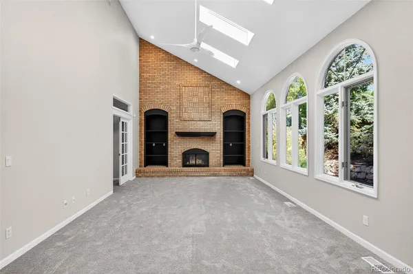 a view of an empty room with a fireplace and a window