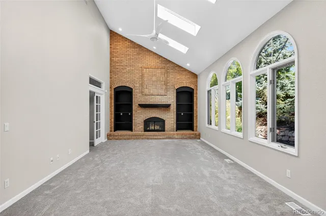 a view of an empty room with a fireplace and a window