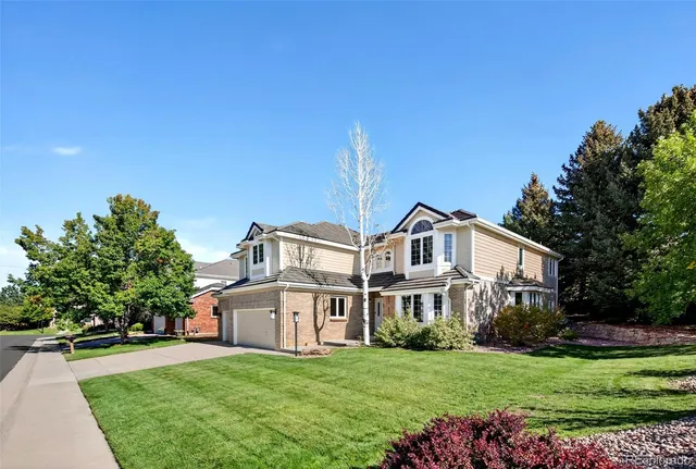 a view of a house with a big yard plants and large trees