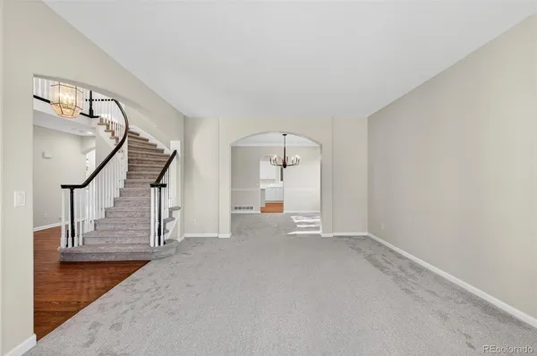 a view of empty room with stairs and wooden floor