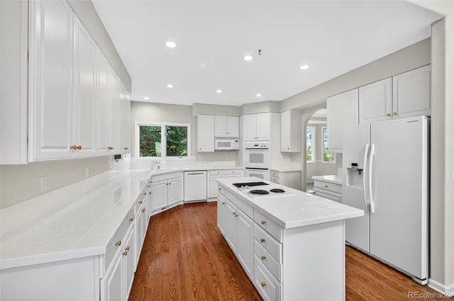 a kitchen with white cabinets and white appliances
