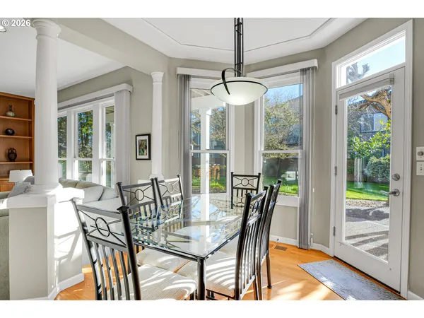 a dining room with furniture a chandelier and wooden floor