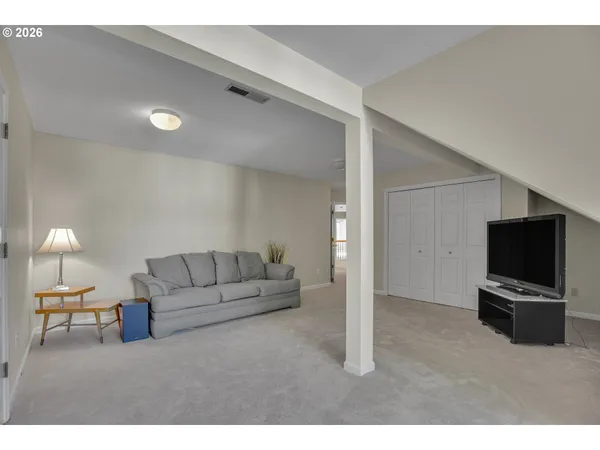 a view of an empty room with furniture and a flat screen tv