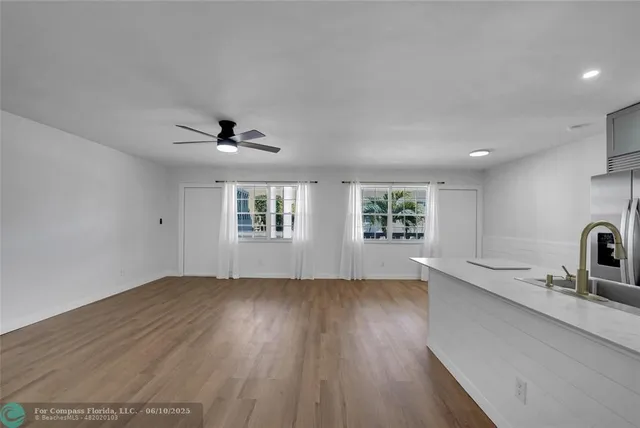 a view of a livingroom with wooden floor and a ceiling fan