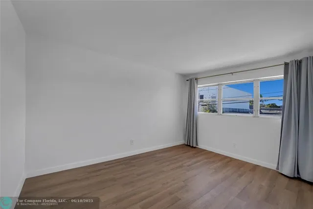 a view of empty room with wooden floor and cabinet