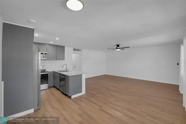a view of kitchen with sink and wooden floor
