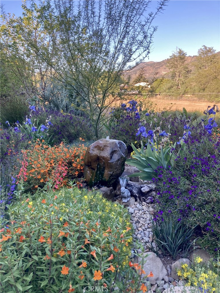 240 Portal Street Oak View, CA 93022 - Photo 8 of 75 a view of a garden with a lot of flower plants and wooden fence