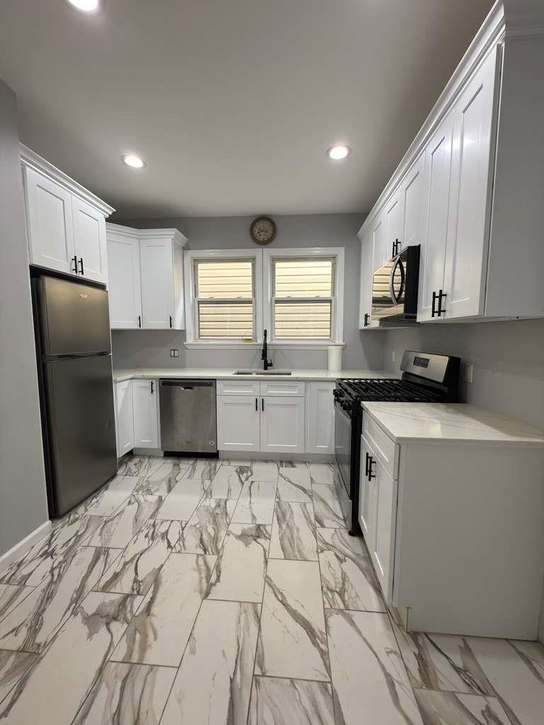 275 Highland Avenue, Unit 1 Kearny, NJ 07032 - Photo 2 of 8 a kitchen with granite countertop a refrigerator stove top oven and sink