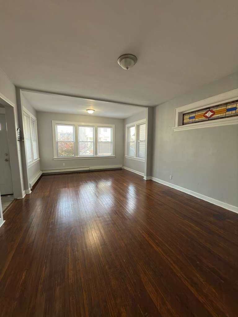 275 Highland Avenue, Unit 1 Kearny, NJ 07032 - Photo 3 of 8 an empty room with wooden floor and windows